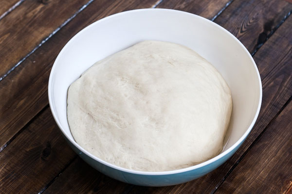 Raised dough in a plastic bowl